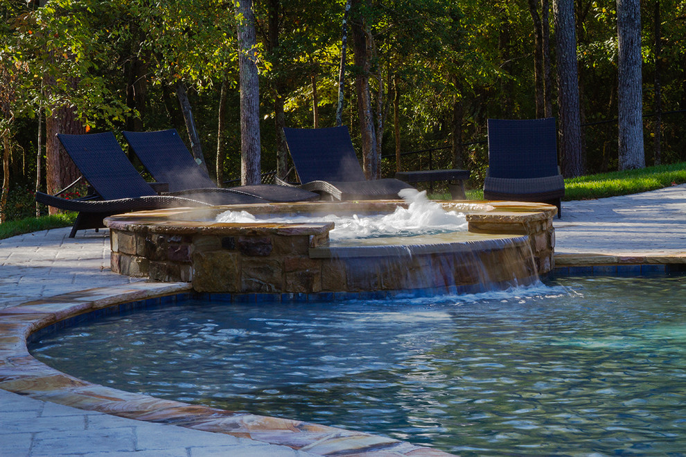 Immagine di una grande piscina naturale tradizionale personalizzata dietro casa con una vasca idromassaggio