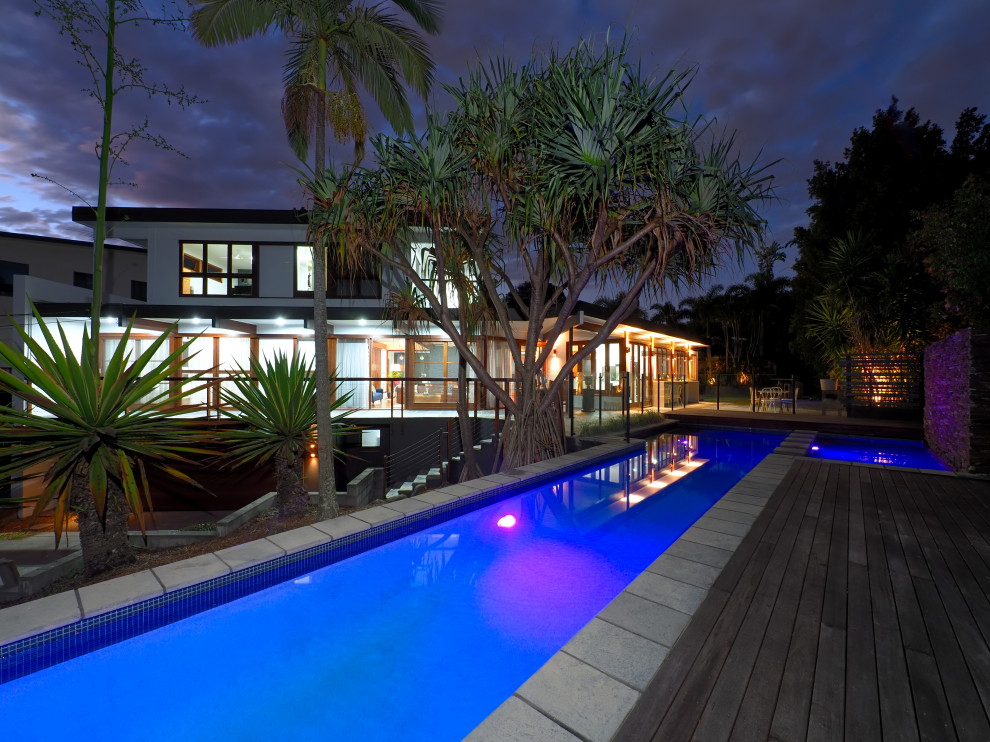 Inspiration pour un couloir de nage arrière vintage rectangle avec une terrasse en bois.