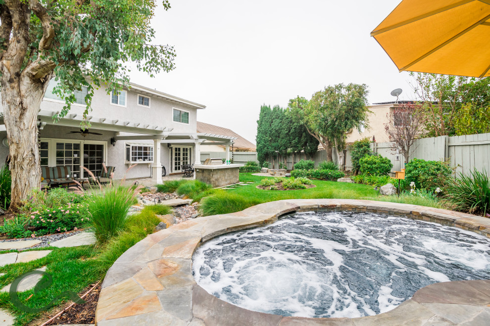 Foto di una piscina fuori terra stile marino personalizzata di medie dimensioni e dietro casa con una vasca idromassaggio e pavimentazioni in cemento