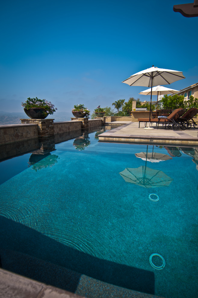Idee per una piscina monocorsia mediterranea rettangolare di medie dimensioni e dietro casa con lastre di cemento