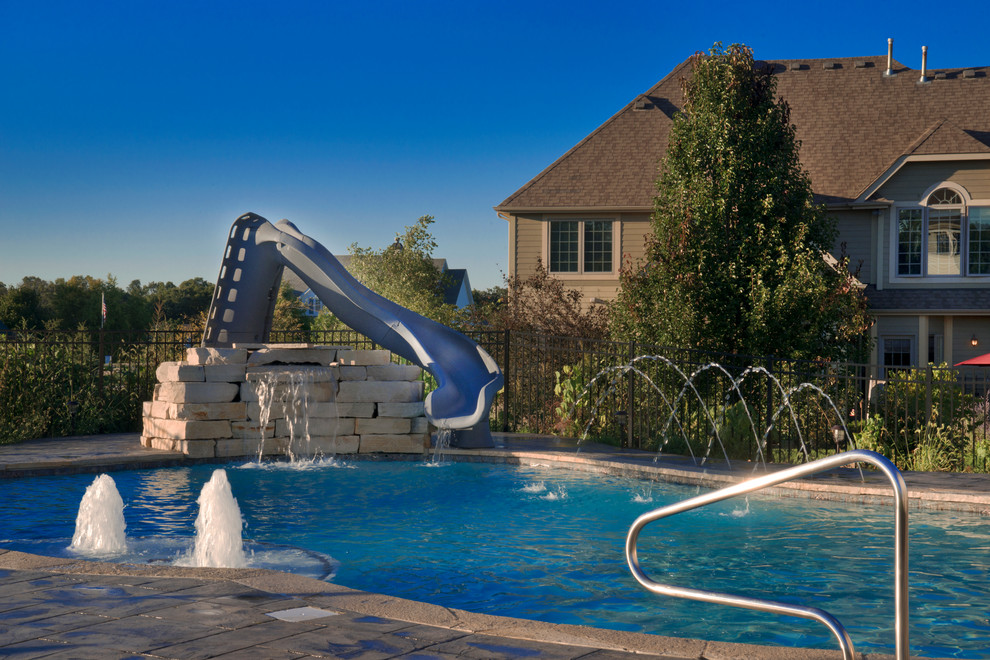 Idee per una piscina classica personalizzata di medie dimensioni e dietro casa con un acquascivolo e pavimentazioni in cemento