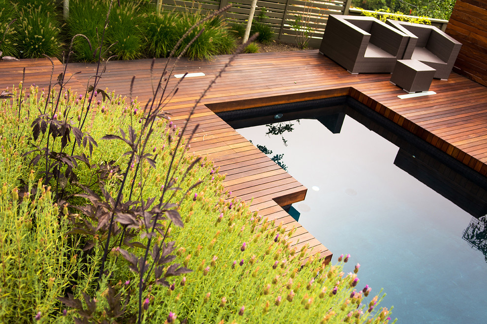 Foto de piscina con fuente alargada vintage de tamaño medio rectangular en patio trasero con entablado