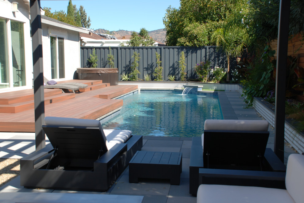 Esempio di una piccola piscina design rettangolare dietro casa con pavimentazioni in cemento