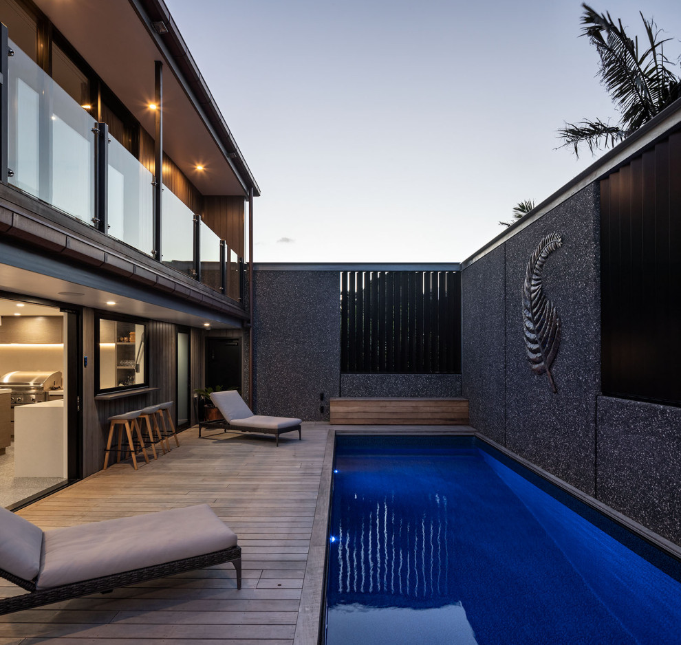 Cette image montre une très grande piscine sur toit hors-sol urbaine rectangle avec des solutions pour vis-à-vis et une terrasse en bois.