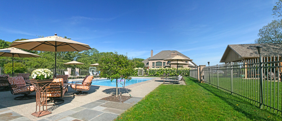 Immagine di una grande piscina classica rettangolare dietro casa con una dépendance a bordo piscina e pavimentazioni in pietra naturale