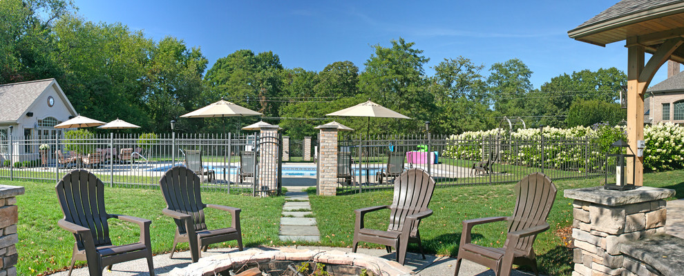 На фото: большой прямоугольный бассейн на заднем дворе в классическом стиле с домиком у бассейна и покрытием из каменной брусчатки с