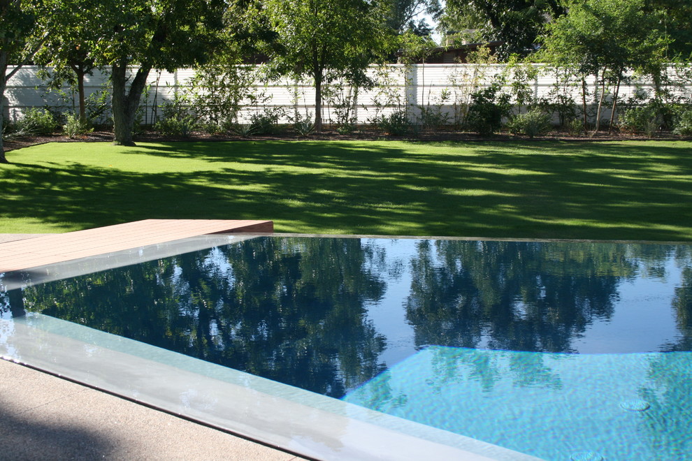 Mid-sized trendy backyard concrete and custom-shaped infinity pool photo in Phoenix