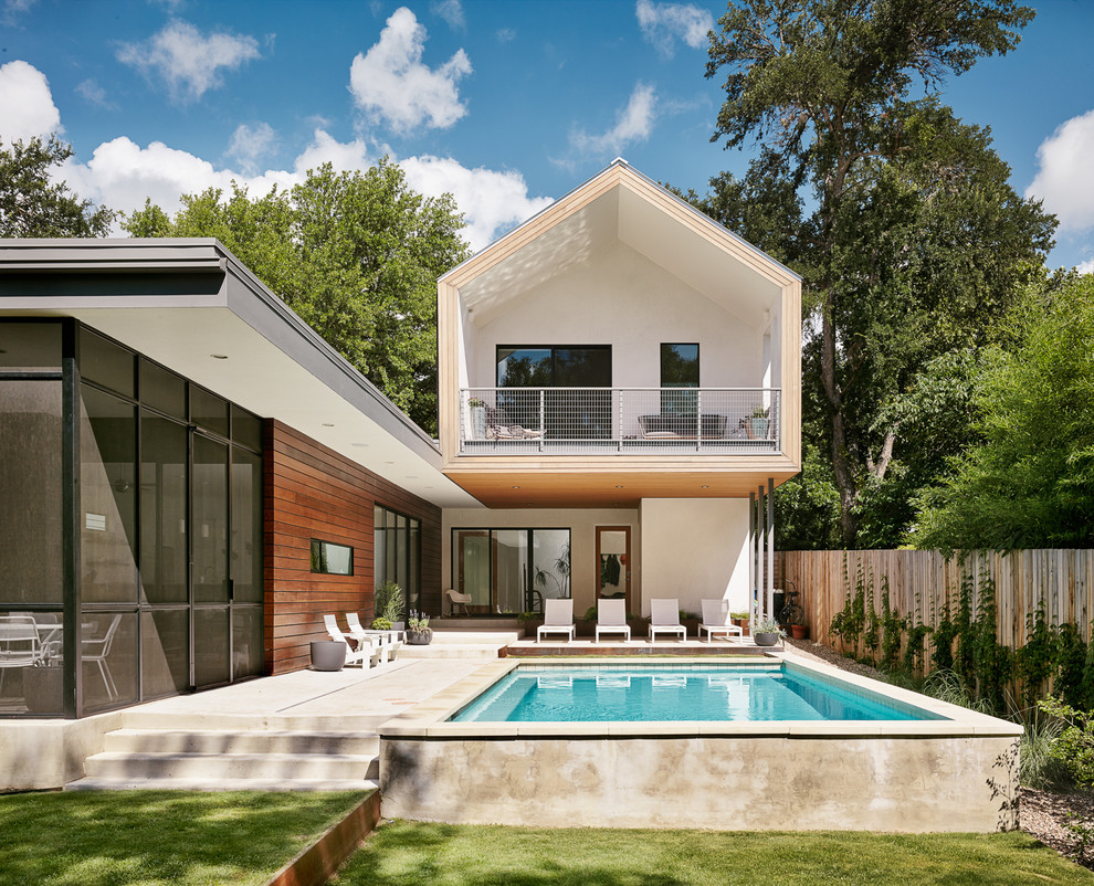 Ispirazione per una piscina design rettangolare dietro casa e di medie dimensioni con pavimentazioni in cemento