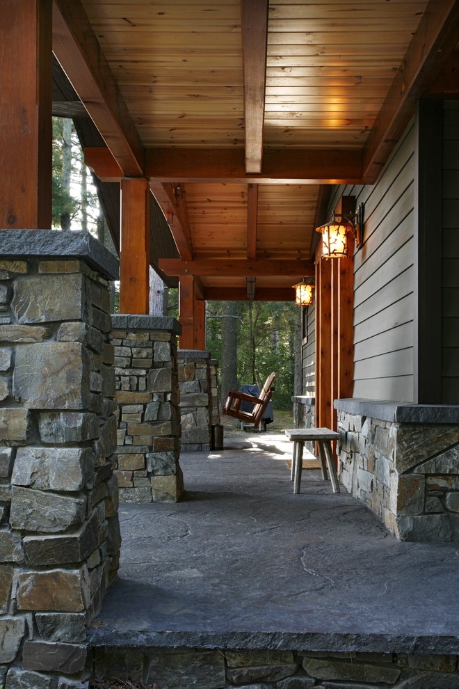 На фото: веранда среднего размера на переднем дворе в стиле рустика с покрытием из декоративного бетона и навесом
