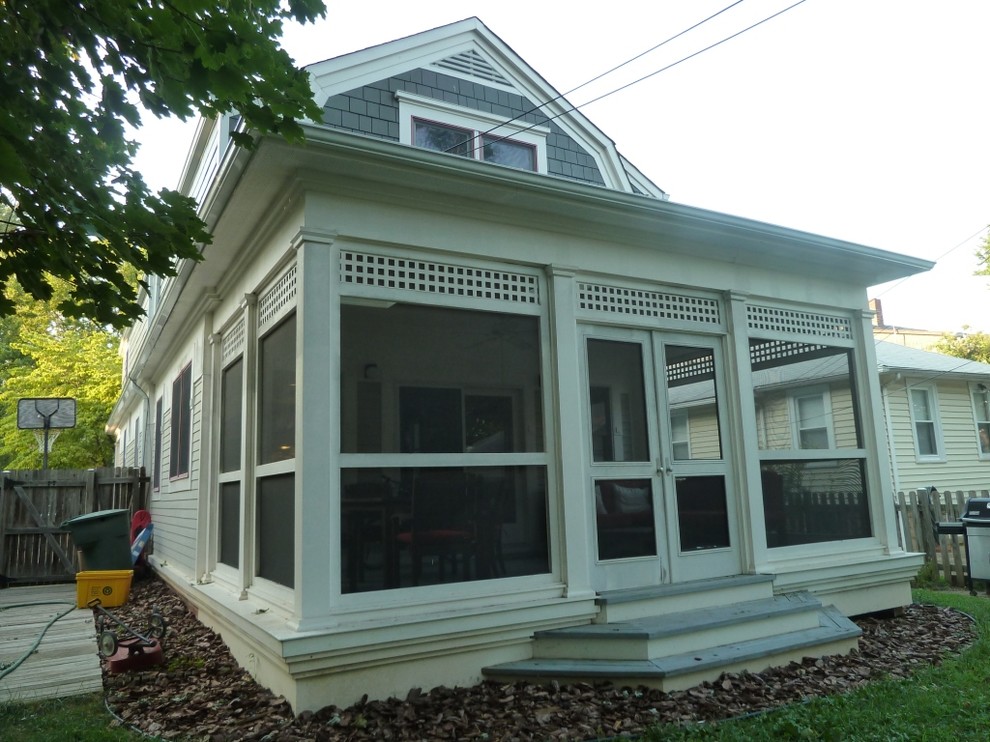 Idée de décoration pour un petit porche d'entrée de maison arrière craftsman avec une moustiquaire et une extension de toiture.