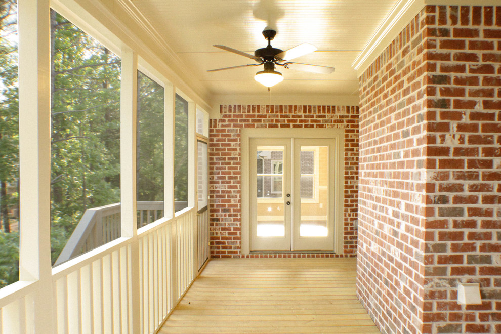 Exemple d'un grand porche d'entrée de maison arrière craftsman avec une moustiquaire, une terrasse en bois et une extension de toiture.
