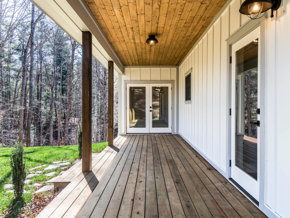 Mid-sized farmhouse back porch idea in Other with decking and a roof extension