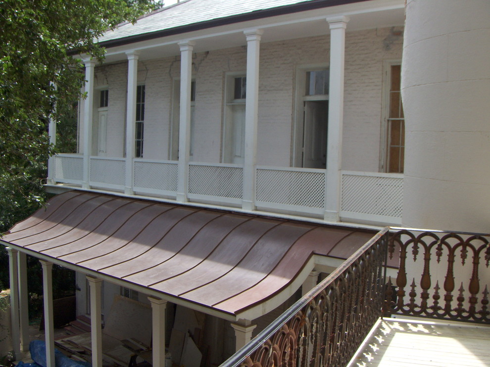 Idées déco pour un très grand porche d'entrée de maison arrière classique avec des pavés en pierre naturelle et une extension de toiture.