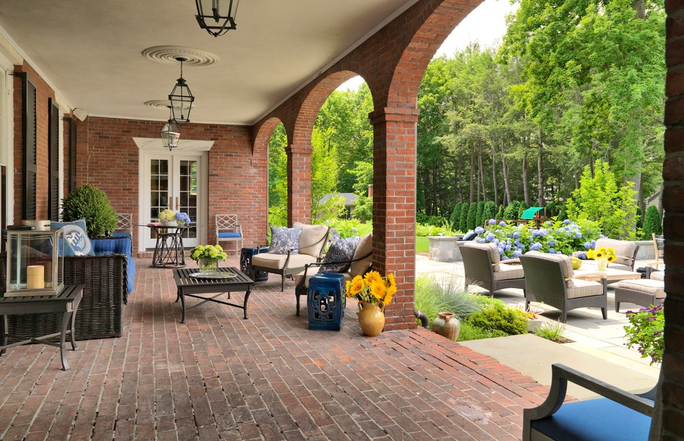Classic veranda in Boston with brick paving, a roof extension and feature lighting.