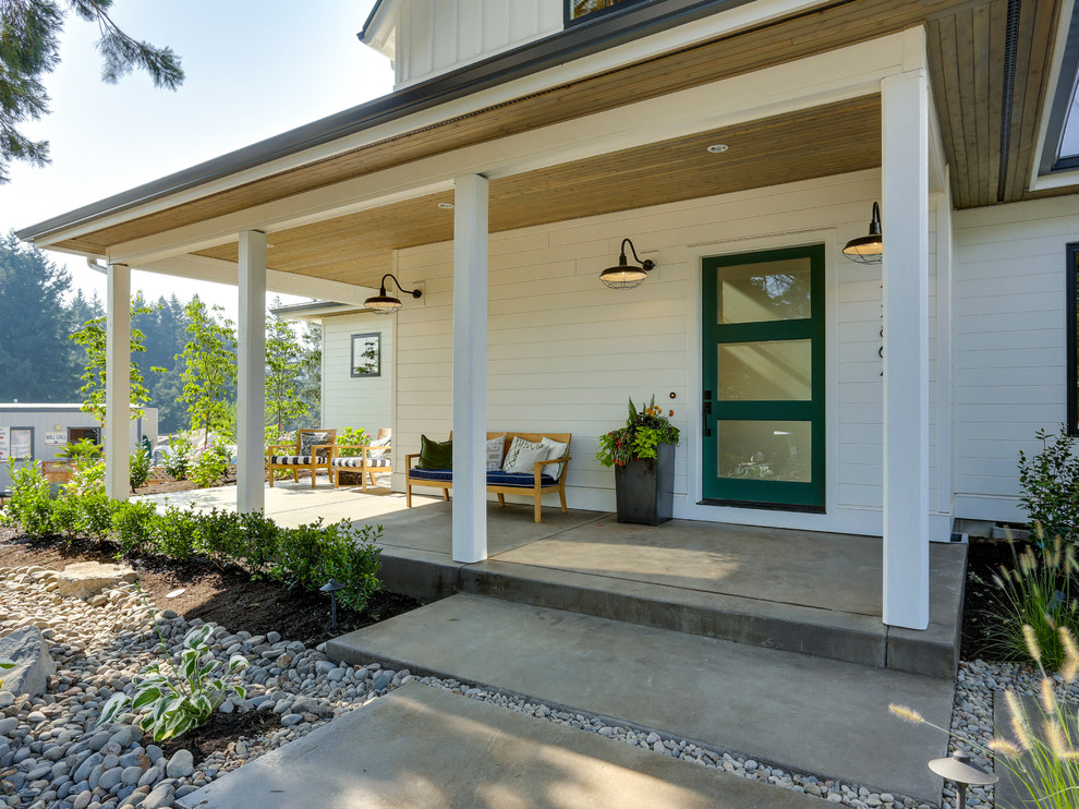 Exemple d'un très grand porche d'entrée de maison avant nature avec des pavés en béton et une extension de toiture.