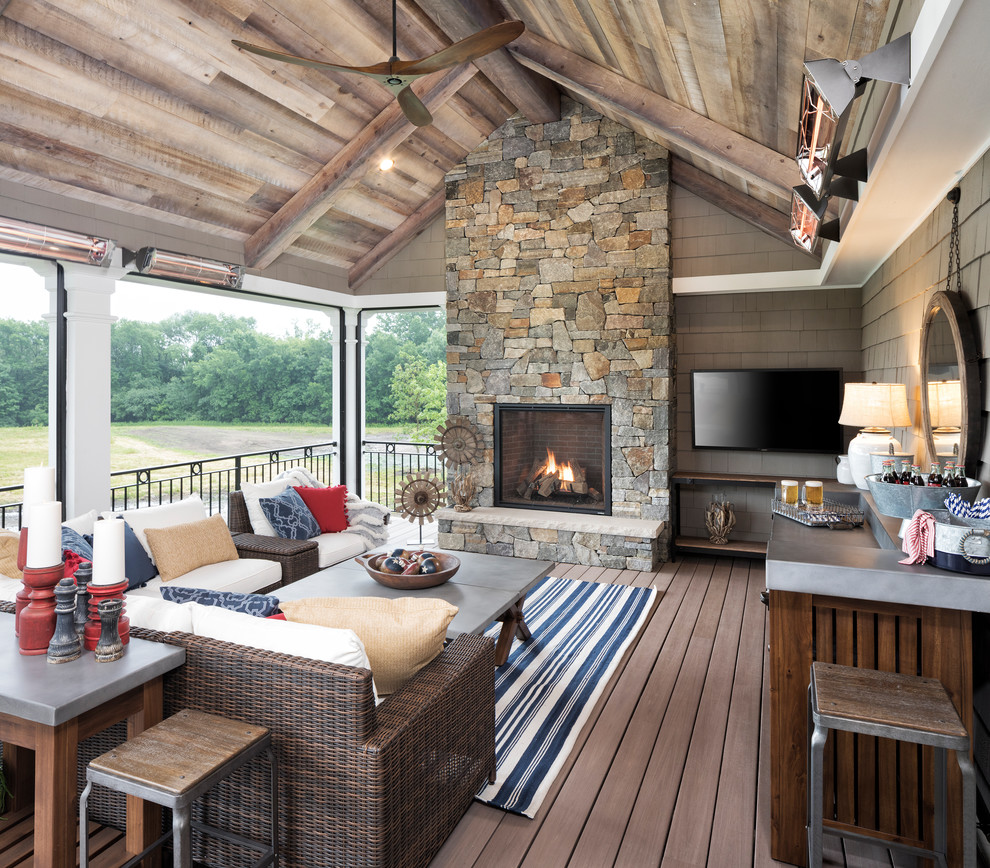 This is an example of a rustic back veranda in Minneapolis with a fireplace, decking and a roof extension.