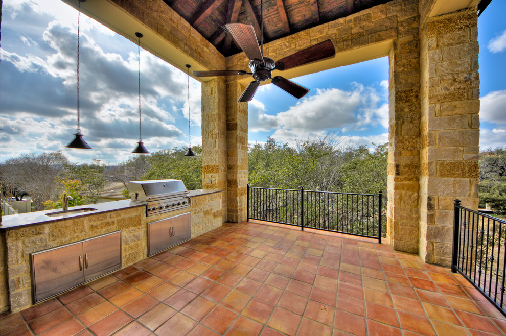Cette image montre un grand porche d'entrée de maison arrière méditerranéen avec une cuisine d'été, du carrelage et une extension de toiture.