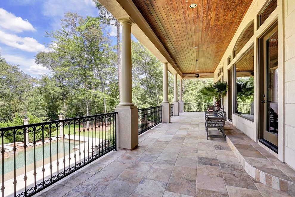 Huge tuscan tile back porch photo in Houston with a roof extension