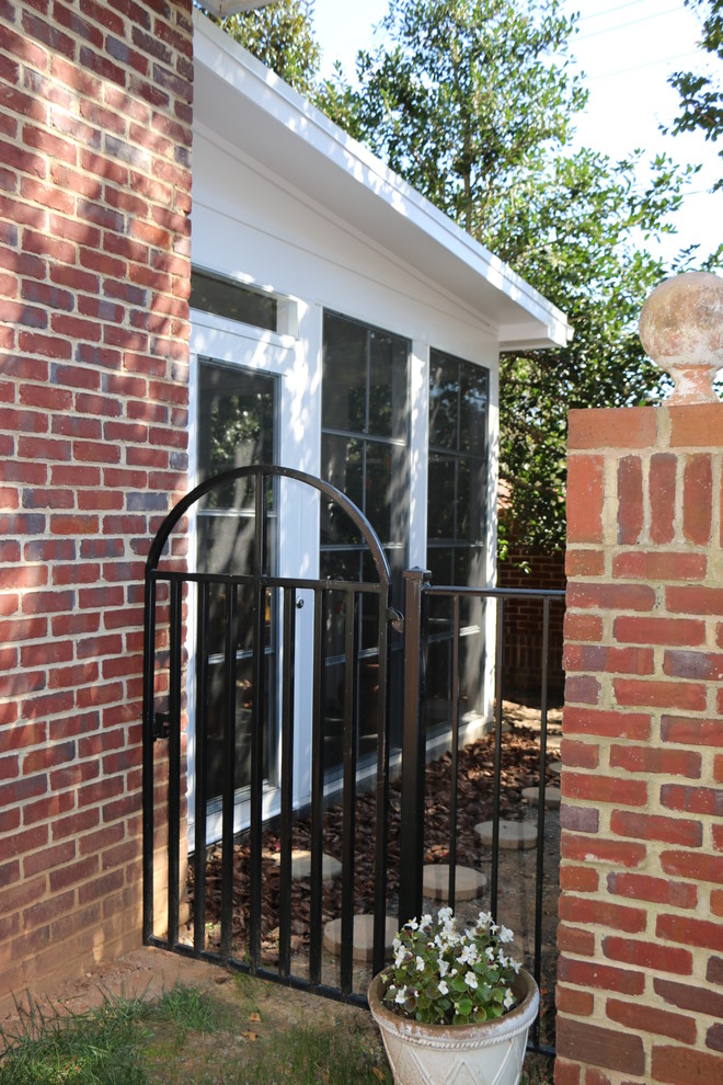 На фото: огромная веранда на заднем дворе в классическом стиле с крыльцом с защитной сеткой, покрытием из декоративного бетона и навесом