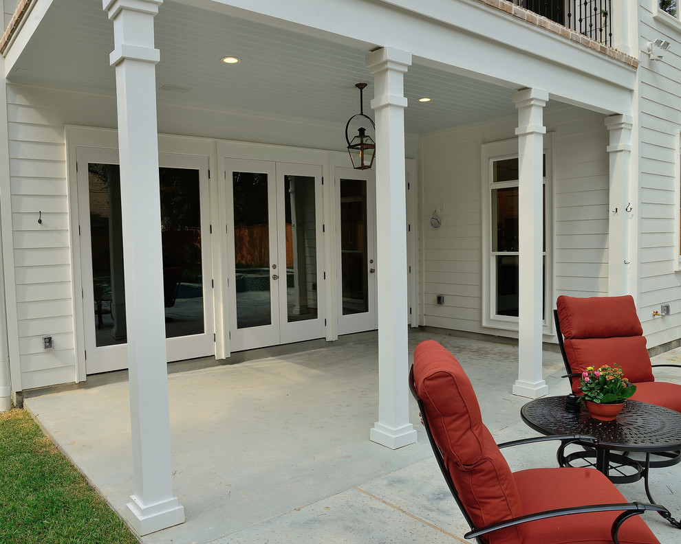 Diseño de terraza clásica grande en patio trasero y anexo de casas con adoquines de hormigón