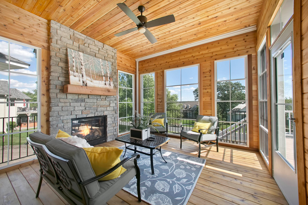 Photo of a large back veranda in Minneapolis with a fireplace, decking and a roof extension.