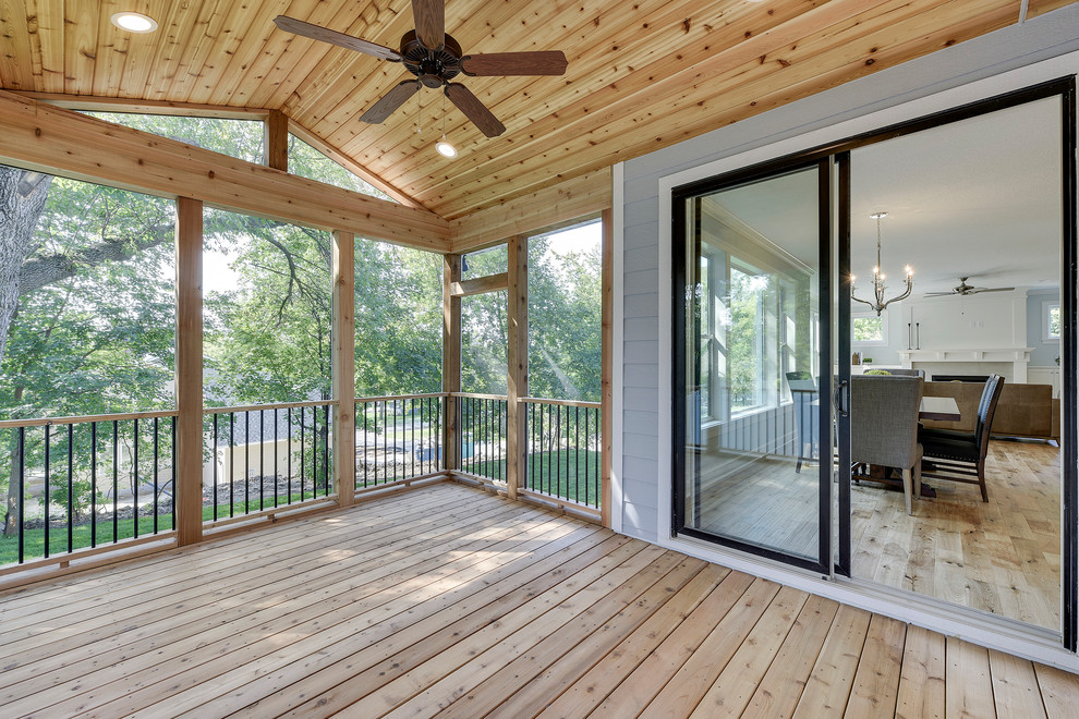 Large classic screened-in back porch idea in Minneapolis with decking and a roof extension