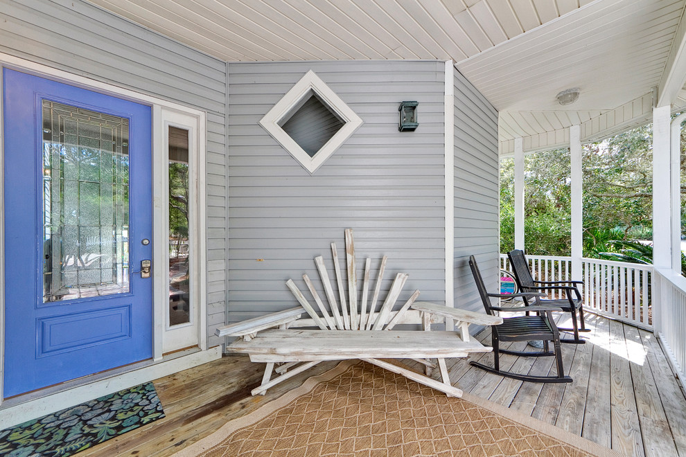 Inspiration for a coastal front porch remodel in Miami with decking and a roof extension