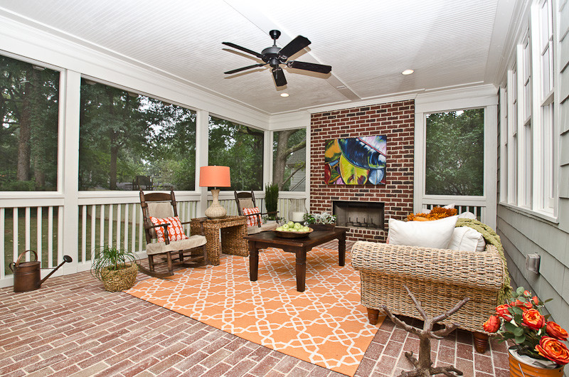 Cette photo montre un grand porche d'entrée de maison arrière craftsman avec une moustiquaire, des pavés en brique et une extension de toiture.