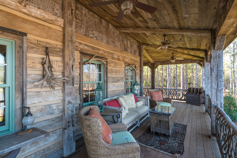 Idées déco pour un porche d'entrée de maison montagne avec une terrasse en bois et une extension de toiture.
