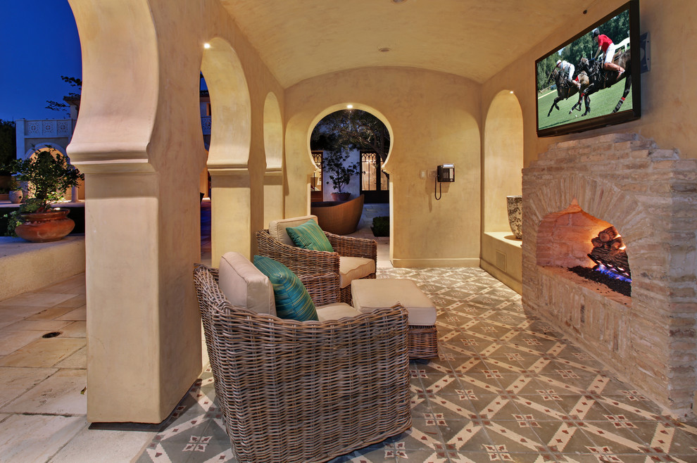 Example of a tuscan patio design in Orange County with a fire pit