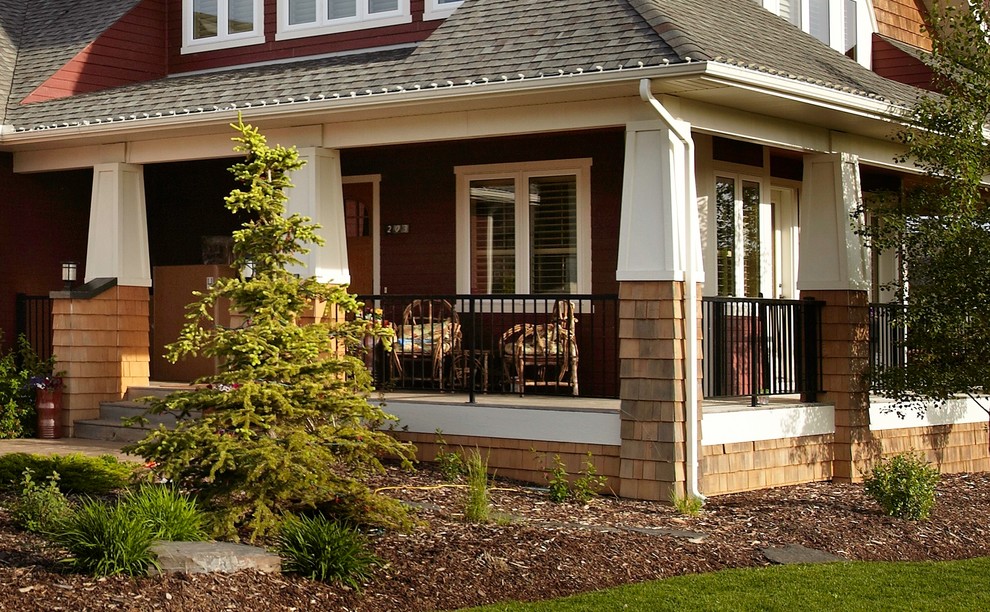 This is an example of a mid-sized craftsman concrete front porch design in Calgary with a roof extension.