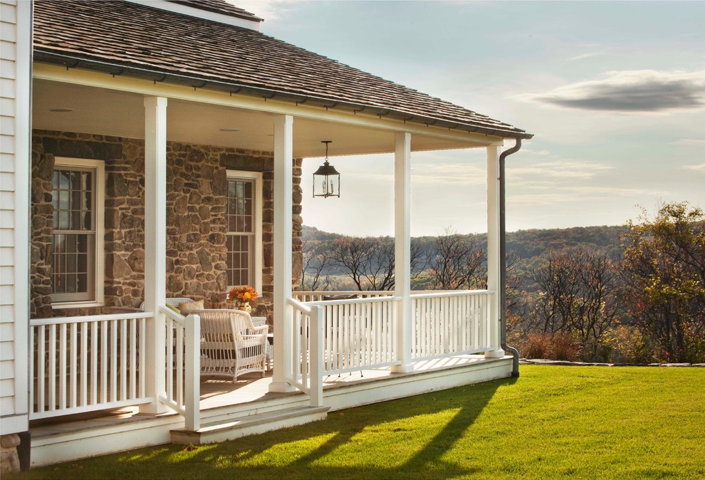 Cette image montre un porche d'entrée de maison arrière rustique avec une terrasse en bois et une extension de toiture.