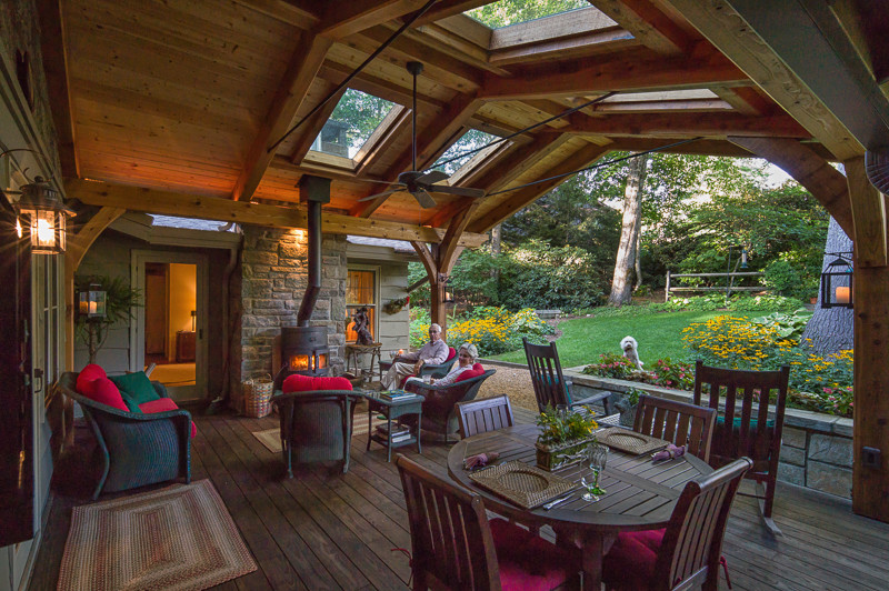 Idées déco pour un grand porche d'entrée de maison arrière montagne avec un foyer extérieur et une terrasse en bois.