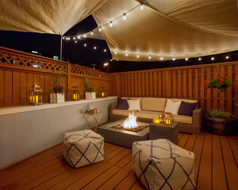 Mountain style back porch idea in New York with a fire pit, decking and an awning