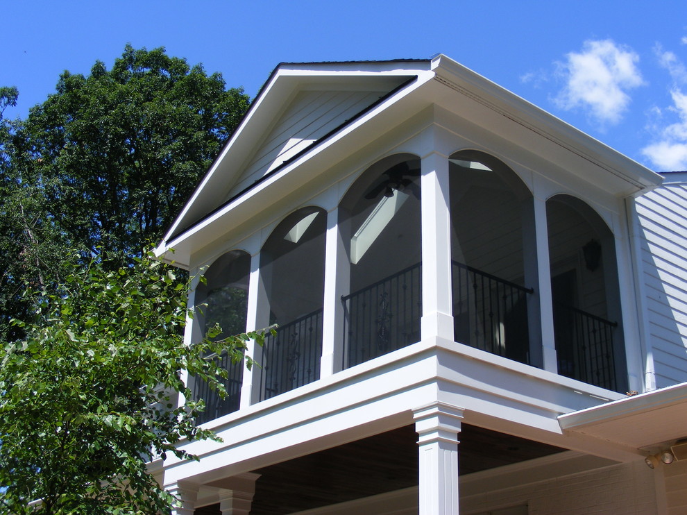 Immagine di un grande portico classico davanti casa con un portico chiuso, pedane e un tetto a sbalzo