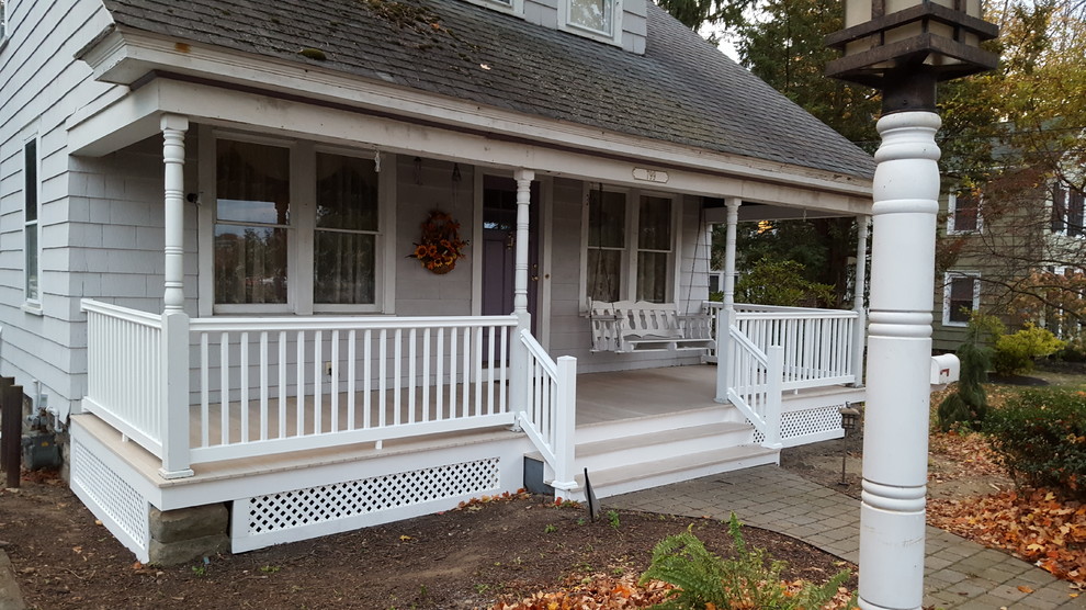Idées déco pour un porche d'entrée de maison avant classique de taille moyenne avec des pavés en béton et une extension de toiture.