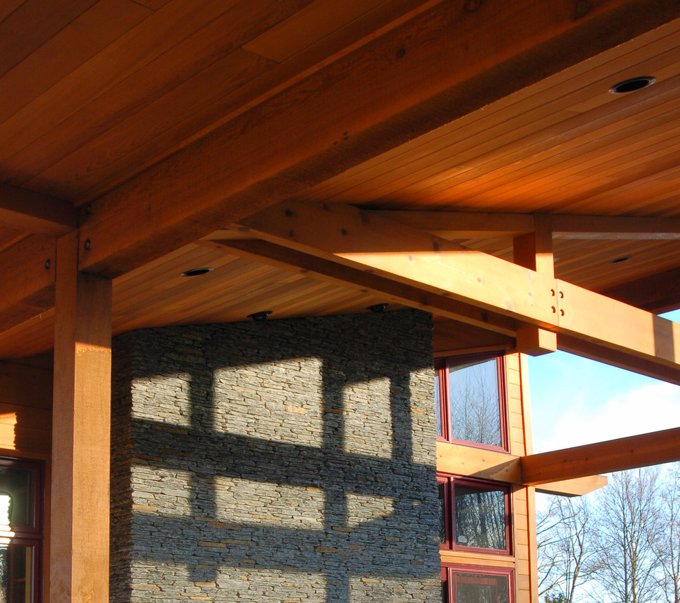 Cette photo montre un porche d'entrée de maison latéral tendance de taille moyenne avec un foyer extérieur, une terrasse en bois et une extension de toiture.