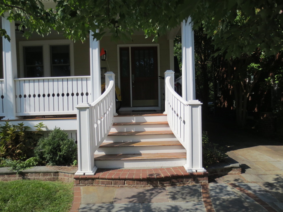 Foto på en liten amerikansk veranda framför huset, med marksten i tegel och takförlängning