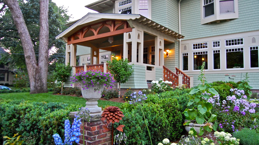 Modelo de terraza de estilo americano grande en patio delantero y anexo de casas con adoquines de ladrillo