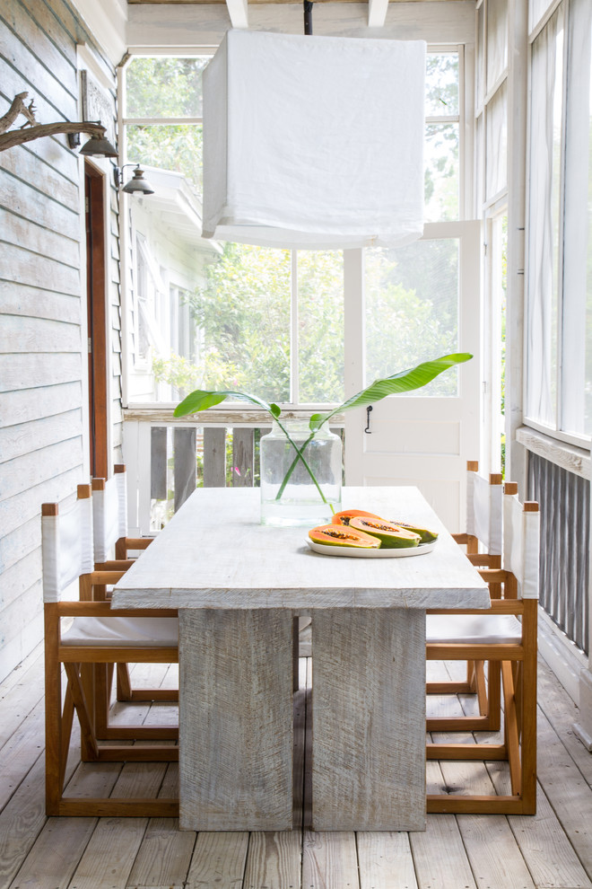 Aménagement d'un porche d'entrée de maison avant bord de mer avec une moustiquaire, une terrasse en bois et une extension de toiture.