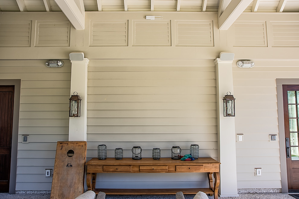 На фото: большая веранда на заднем дворе в современном стиле с покрытием из плитки и навесом с