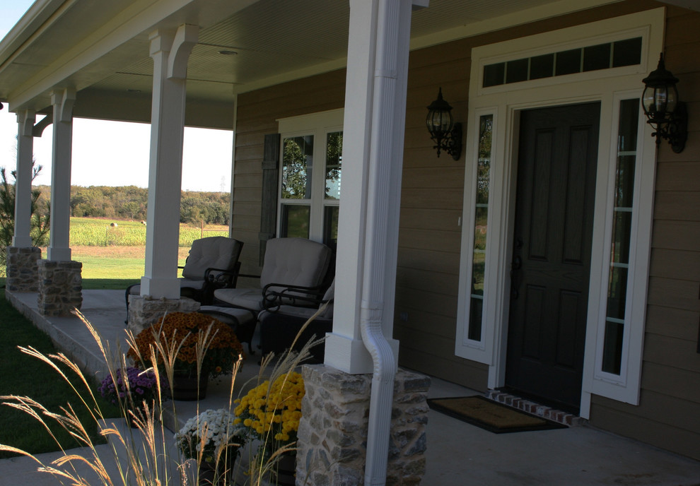 Inspiration pour un porche d'entrée de maison avant rustique de taille moyenne avec une dalle de béton et une extension de toiture.