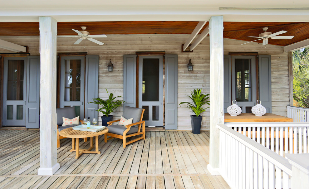Aménagement d'un porche d'entrée de maison bord de mer avec une terrasse en bois et une extension de toiture.