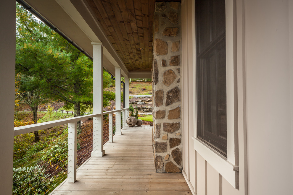 Réalisation d'un porche d'entrée de maison avant champêtre de taille moyenne avec une terrasse en bois et une extension de toiture.