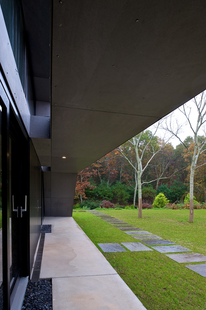 Immagine di un portico minimalista davanti casa con lastre di cemento