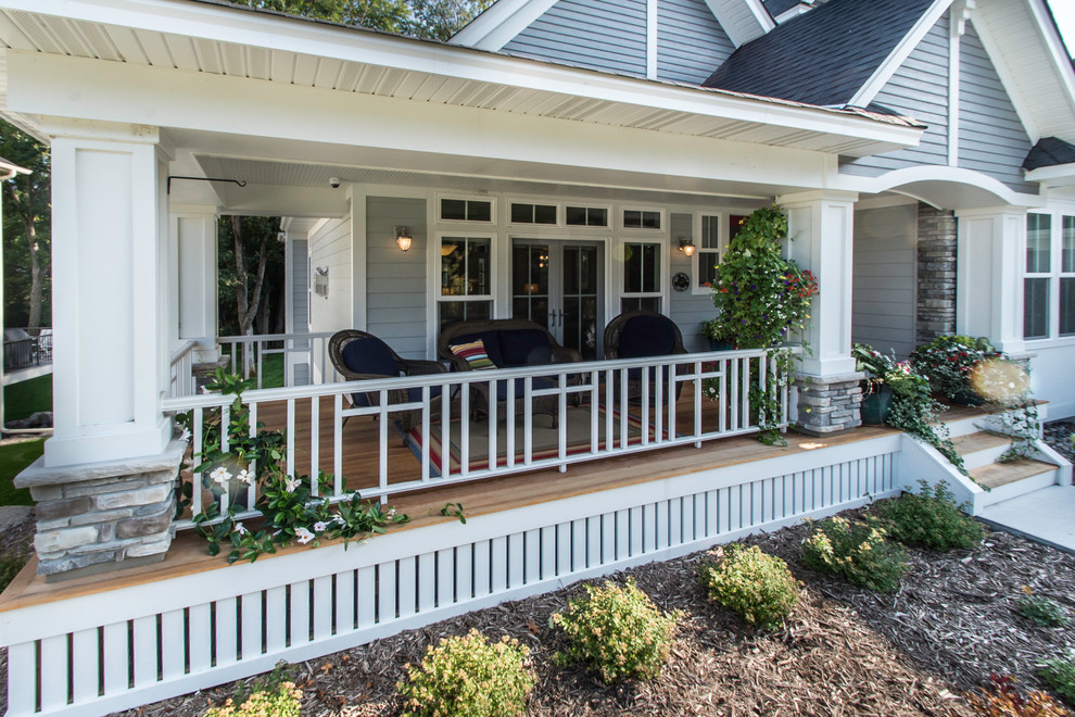 Modelo de terraza de estilo americano de tamaño medio en patio delantero y anexo de casas con entablado