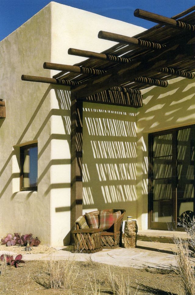 Exemple d'un porche d'entrée de maison latéral sud-ouest américain avec des pavés en pierre naturelle et une pergola.