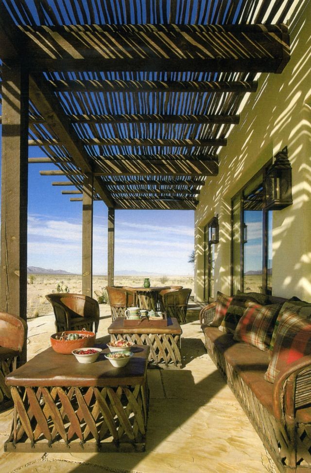 Idéer för amerikanska verandor längs med huset, med naturstensplattor och en pergola
