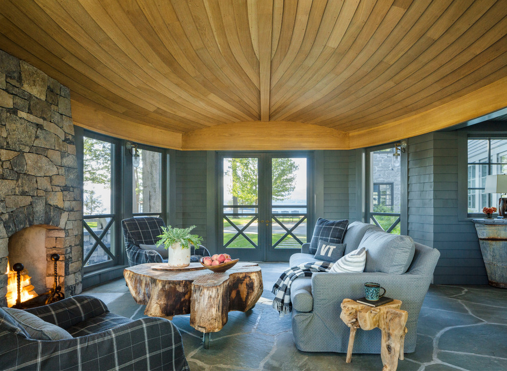 Cette photo montre un grand porche d'entrée de maison bord de mer avec une moustiquaire et des pavés en pierre naturelle.
