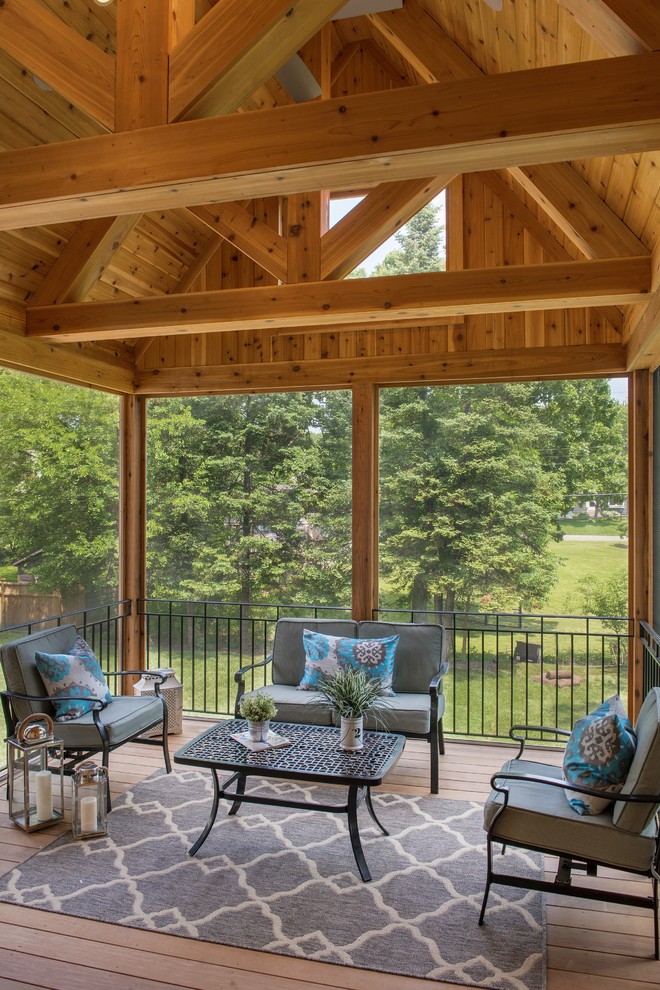 Cette photo montre un porche d'entrée de maison arrière de taille moyenne avec une moustiquaire, une terrasse en bois et un auvent.